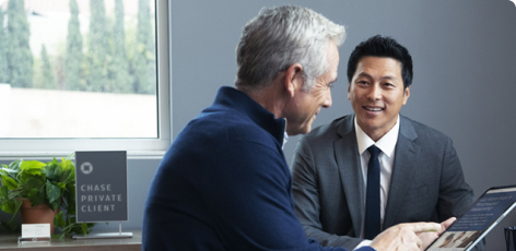 A Chase Private Client Savings customer going over documents on a tablet with their banker