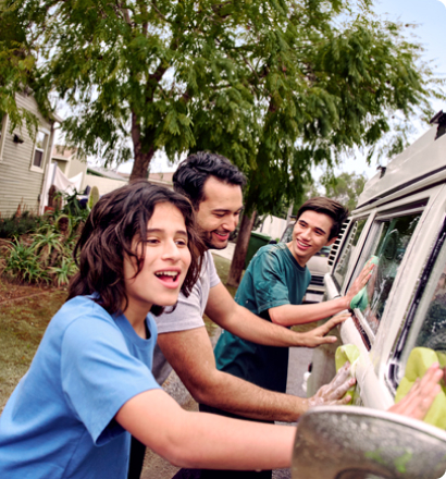 A father and his two sons wash the car together