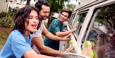 A father and his two sons wash the car together