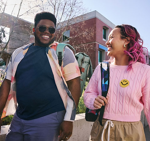 Two college students talking and walking on campus