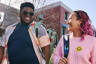 Two college students talking and walking on campus