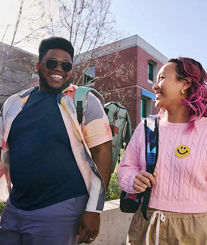 Two college students talking and walking on campus